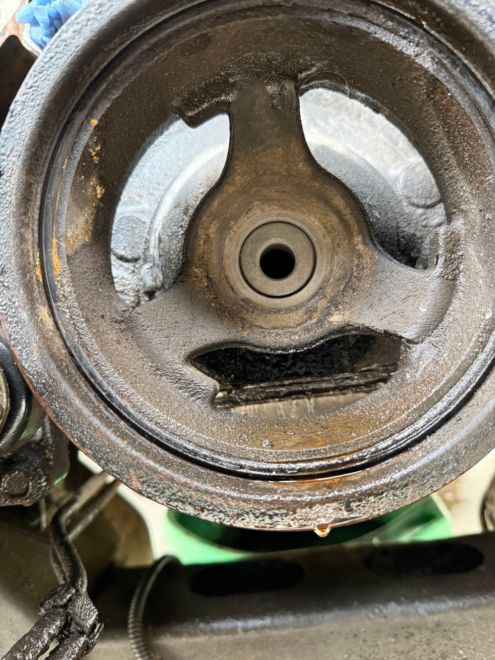 Close-up of a dirty engine component showing oil buildup and wear.