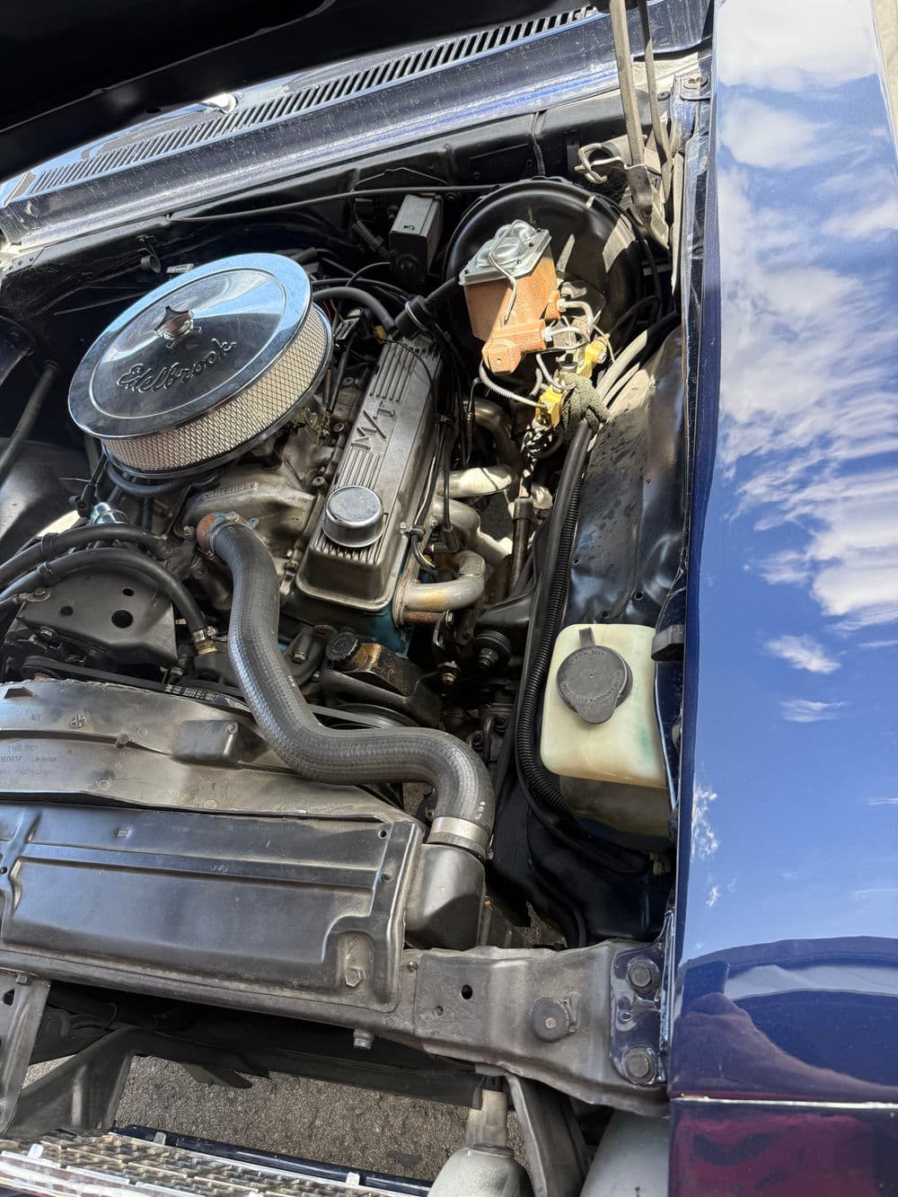 Classic car engine with polished chrome, featuring a V8 and various components visible.