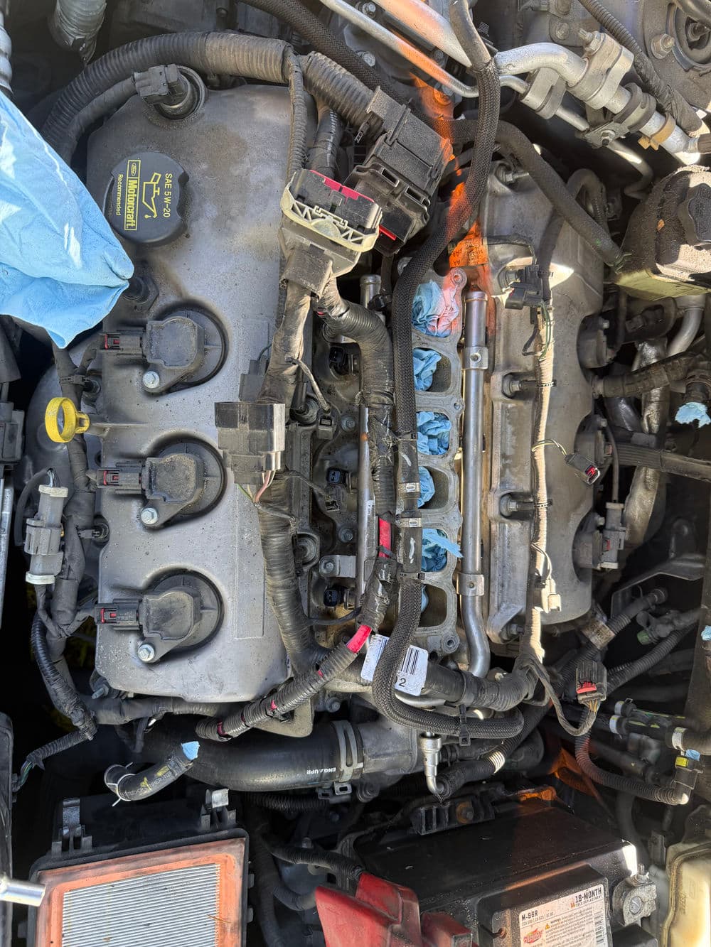 Close-up of an automobile engine with various electrical connections and components visible.
