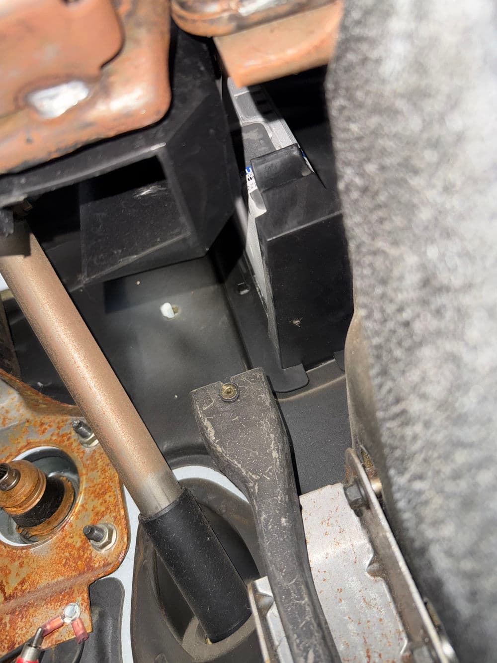 Close-up of automotive interior showing control components and wiring near the dashboard.