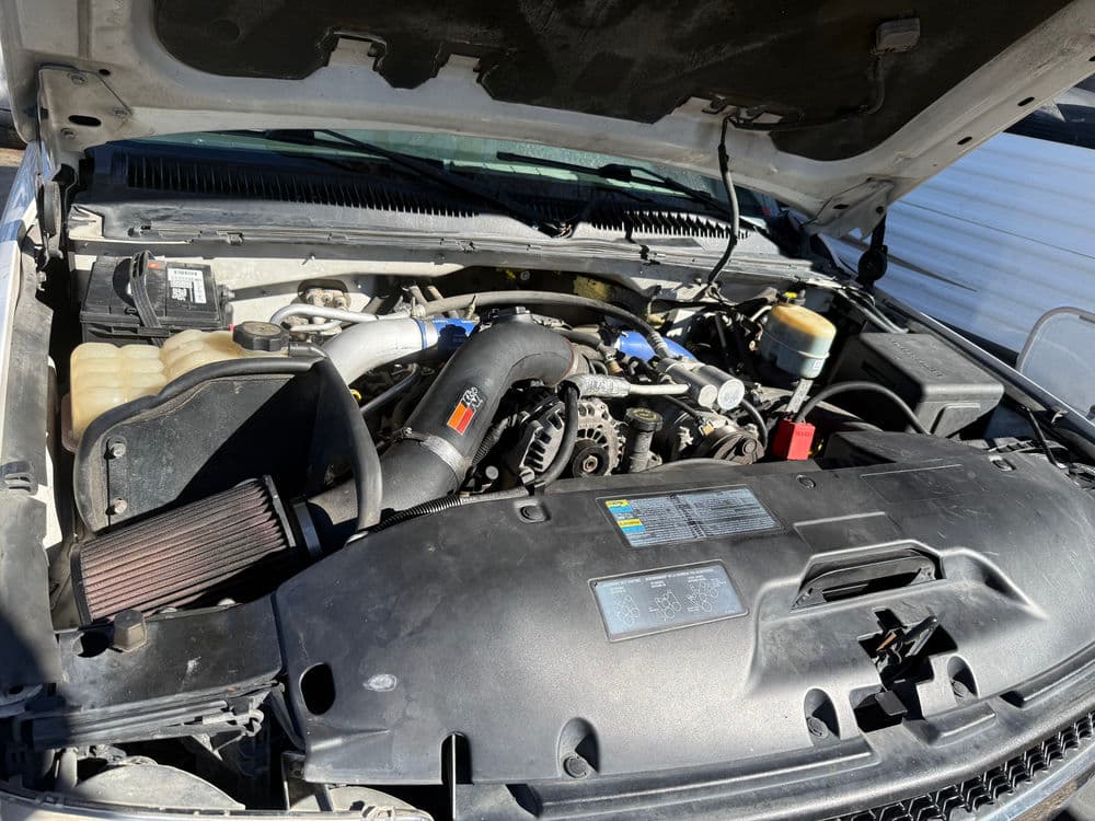 Car engine view showcasing components like the air intake, battery, and radiator.
