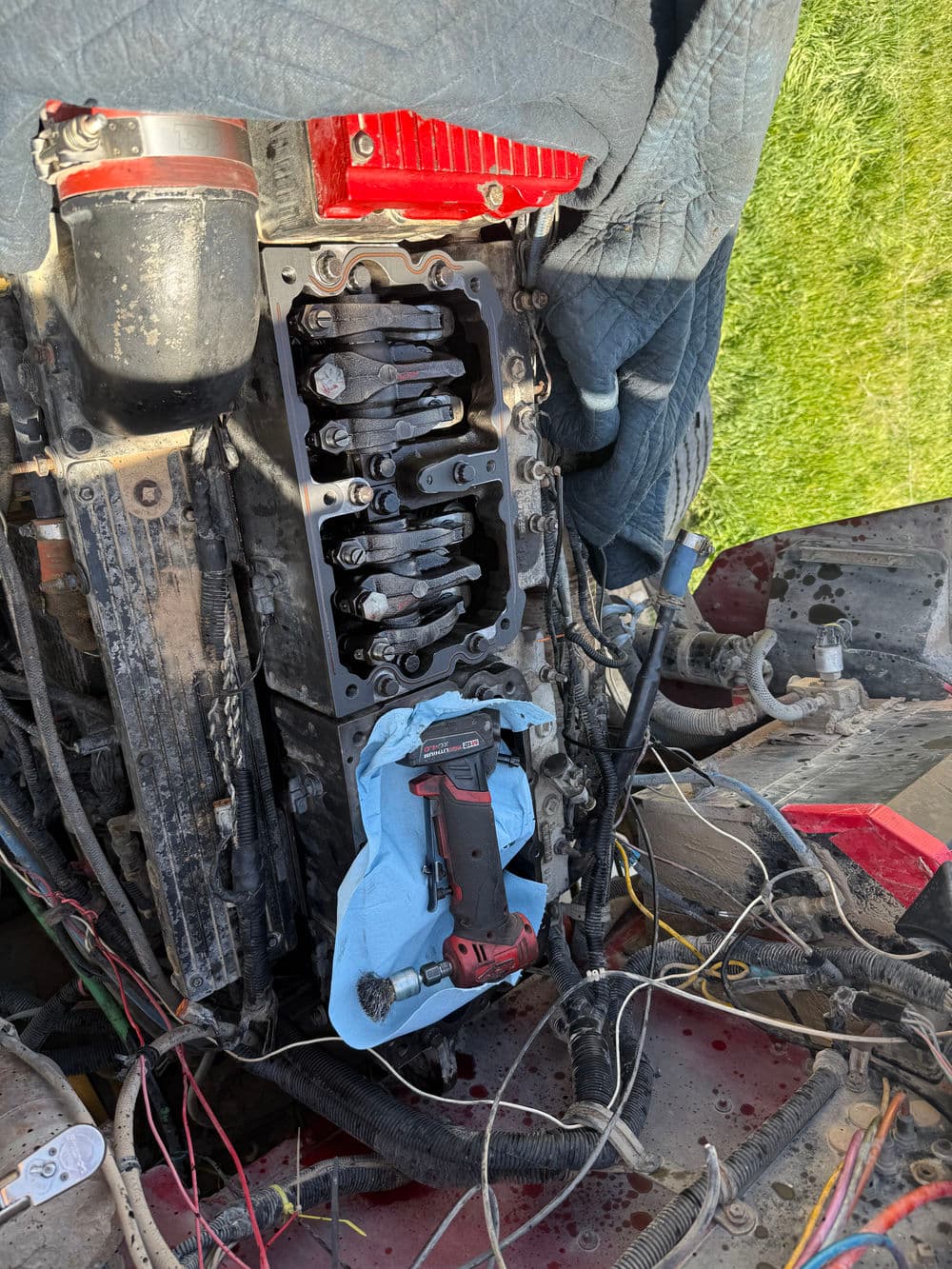 Open engine block with tools and wires, showcasing mechanical repair in progress.