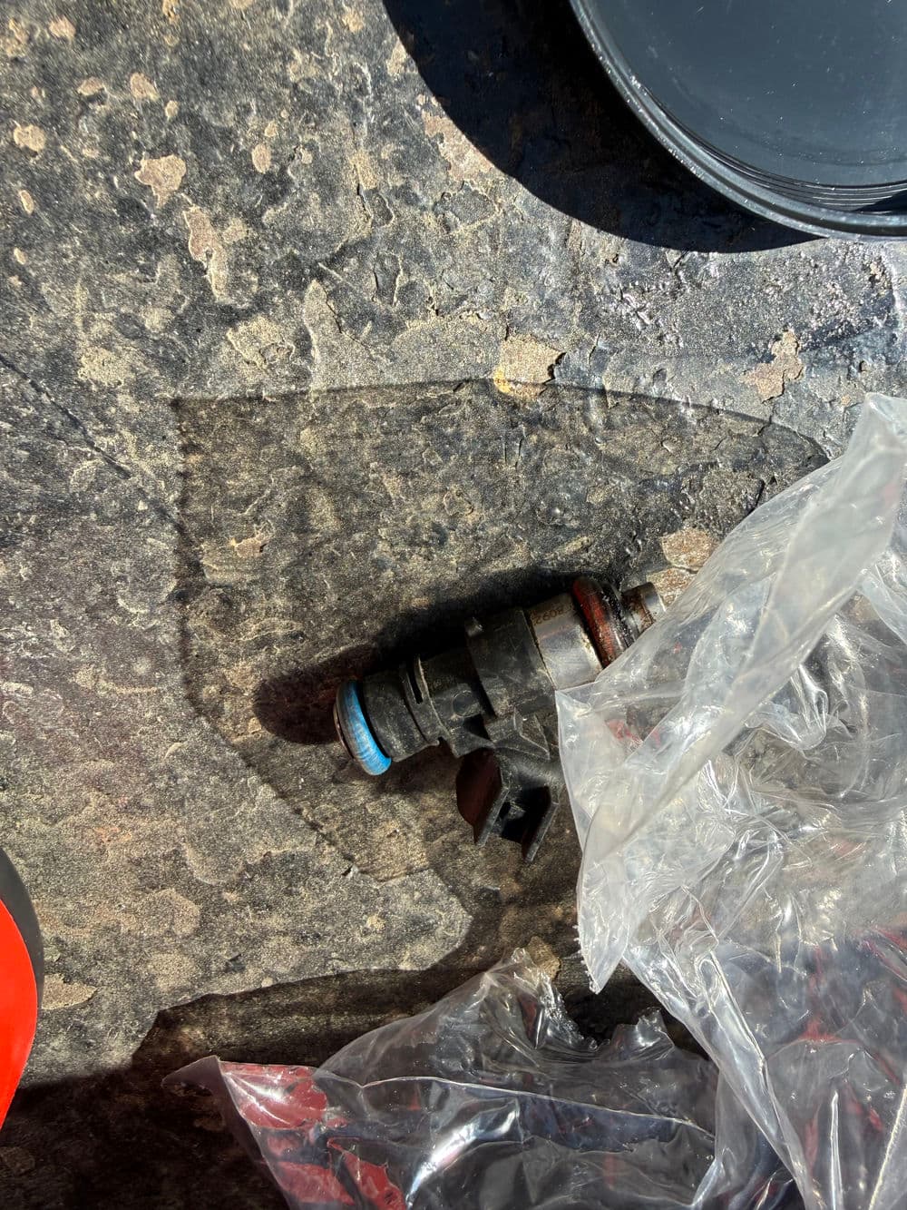 Fuel injector on a textured surface with protective packaging.